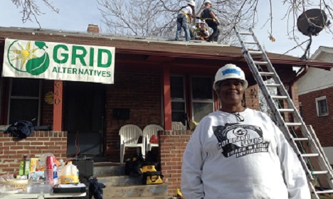 Workers install solar panels on GRID Alternatives building during renovation project