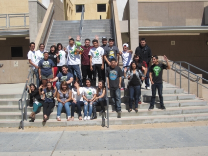 Large diverse group of young people posing together on outdoor steps in front of a building