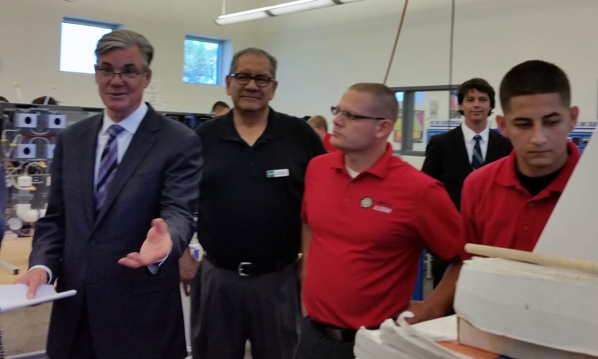 Group of educators and students touring a school workshop or lab facility together