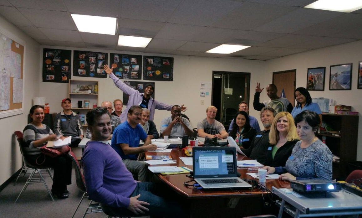 Group of diverse people gathered in classroom for design training wrap-up celebration