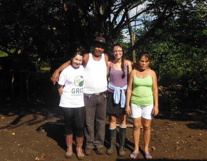 Four people standing together outdoors under trees in Nicaragua, smiling at camera