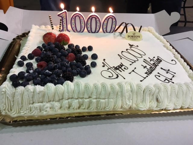 Celebration cake with "1000" candles and berries, commemorating GRID Alternatives' 1000th installation milestone