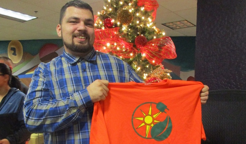 Man holding red flag with sun and circle design at holiday event
