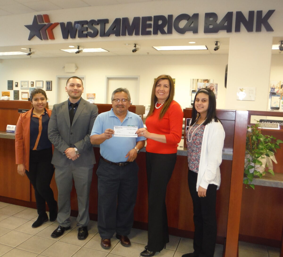 Five bank employees present a check at Westamerica Bank branch