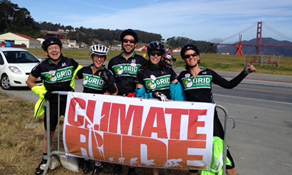 Group of cyclists holding "Climate Ride" banner with Golden Gate Bridge in background