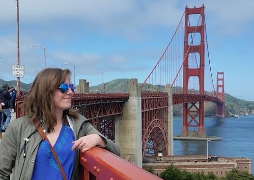 Woman with blue sunglasses at Golden Gate Bridge railing in San Francisco