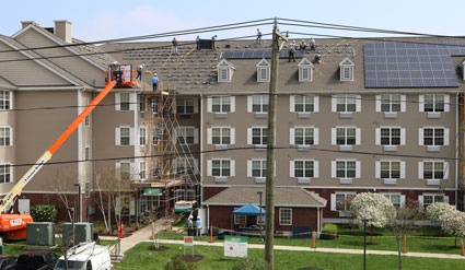 Four-story residential building with construction equipment and spring landscaping in Connecticut