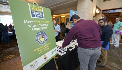 Visitor speaking with Colorado employer representative at job fair expo event