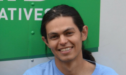 Staff member Matt Wheeler smiling in front of green and white background