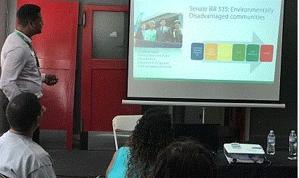 Presenter discussing Senate Bill 535 on environmental health at community outreach event in Long Beach