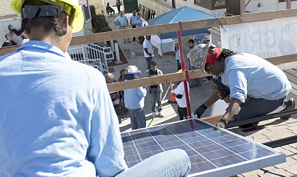Workers installing solar panels on a rooftop during NAACP's Solar Equity Initiative at Jenesse Center