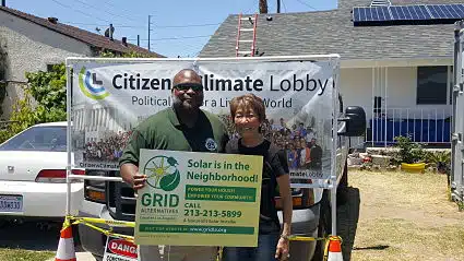 Two individuals stand in front of a house where construction is taking place
