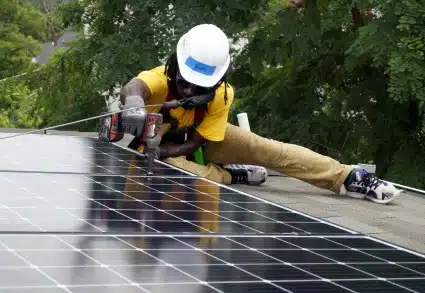 A Solar Works DC job trainee installs a solar panel