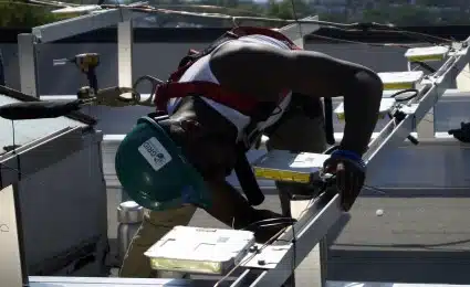 A Solar Works DC job trainee installs an inverter