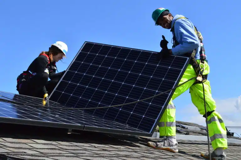 A volunteer and GRID staff member install solar on a roof