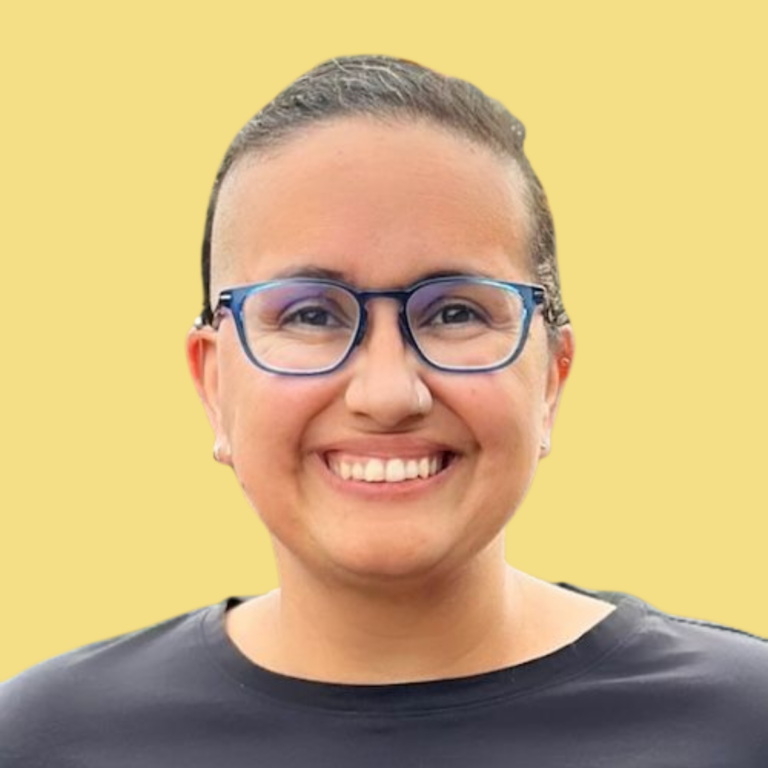Juliana Pino, smiling person wearing glasses and black shirt against yellow background