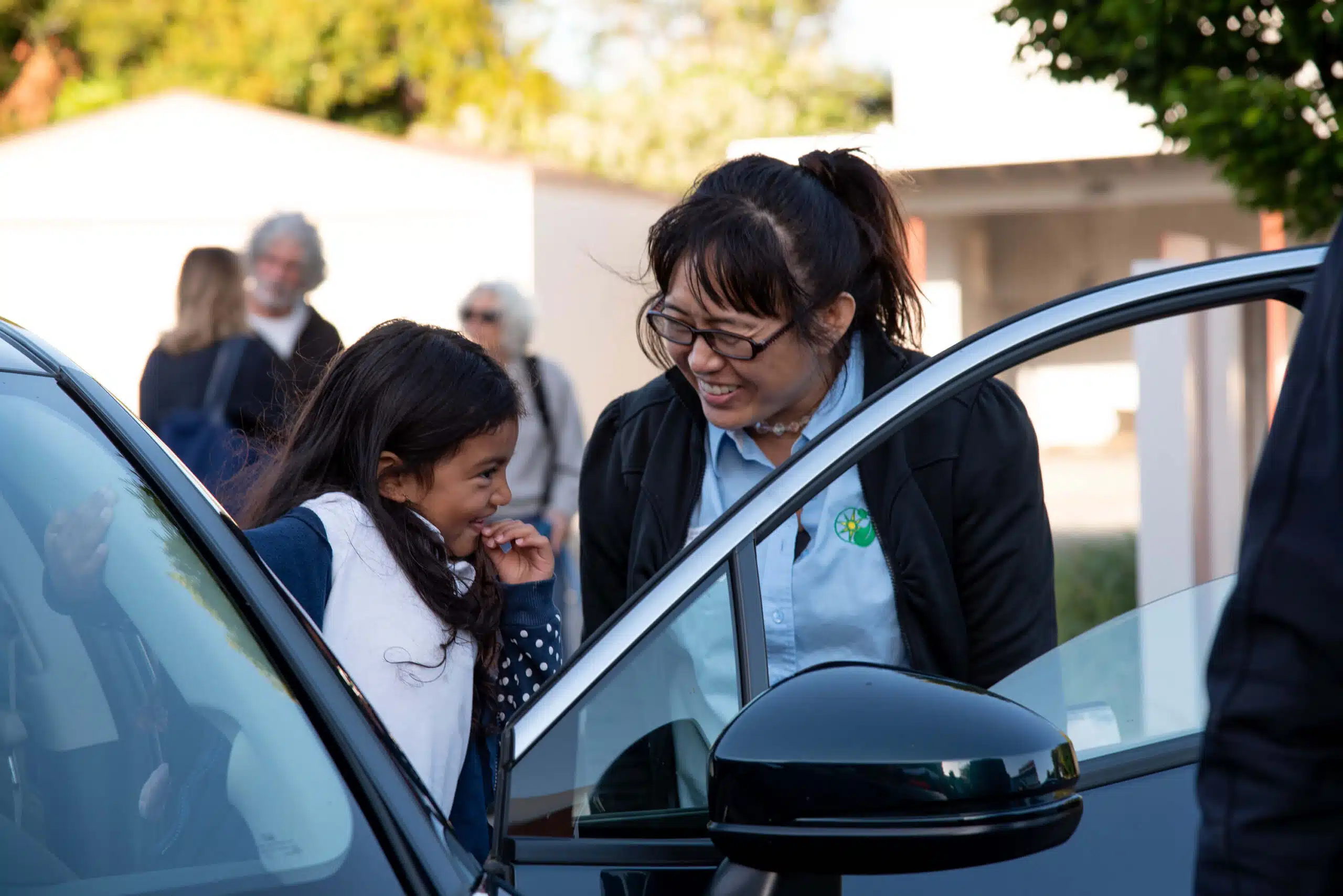Adult and child by car with open door