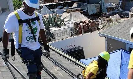 Construction workers in safety gear on a dock with building materials and equipment
