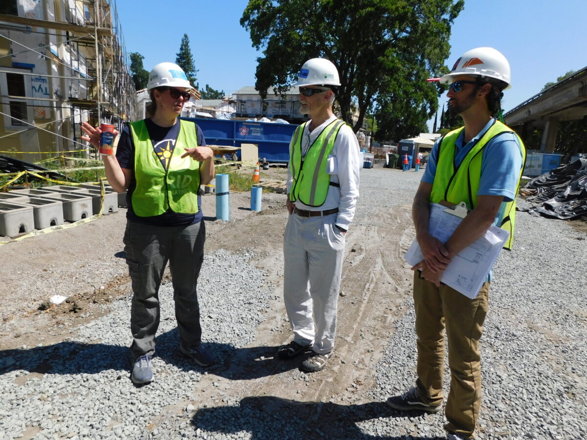 Erica Mackie, GRID Alternatives Co-Founder stands next to Board President Buzz Blacket accompanied by GRID Alternatives Bay Area's System Designer/Project Manager Matthew Kroll