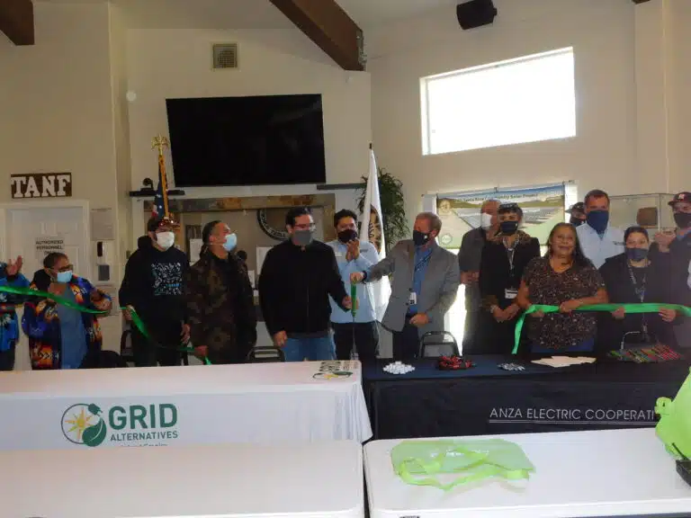 Group of people at ribbon-cutting ceremony for Grid Alternatives and Anza Electric Cooperative solar project event