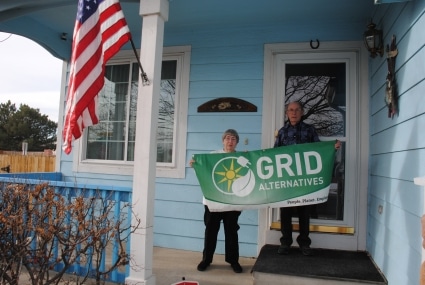 The Comptons hold a GRID banner in front of their home
