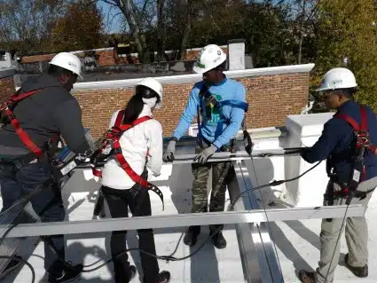 Dominic serving his community, teaching volunteers about solar