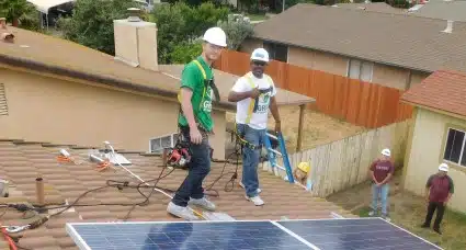 Two GRID volunteers taking a photo on a roof install.