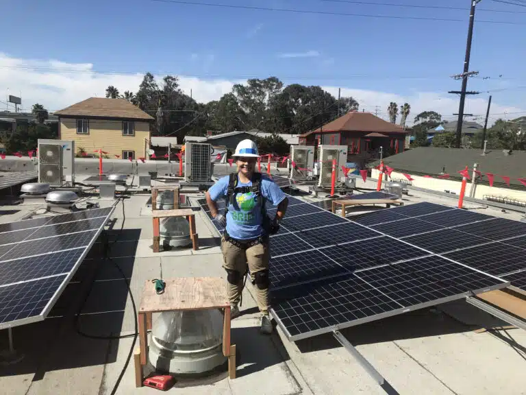 Emily Corrow on a rooftop of a commercial building, next to a solar array.