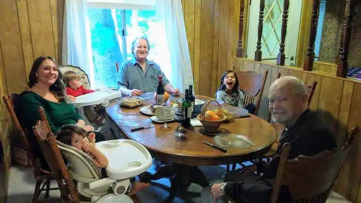 Family gathered around dining table for a meal together indoors