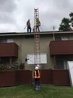 A father and daughter volunteering at an install coordinate the lift of a module