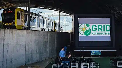 A train passes by an outdoor movie event