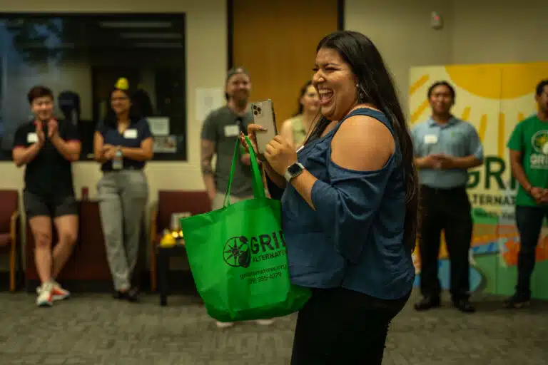 Sophia from Rising Sun Center for Opportunity smiling after winning a green GRID swag bag in a raffle.