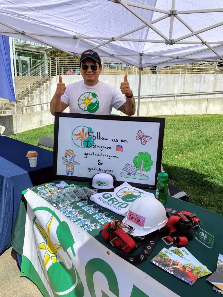 Jose Valverde, Bay Area-North Coast Community Engagement trainee is posing holding his two thumbs up for a picture at a community event in Willits, CA