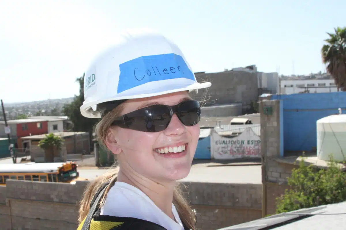 Woman wearing hard hat labeled "Colleen" at construction site