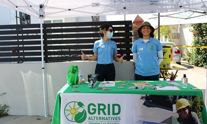 Two GRID Alternatives staff members stand while they table