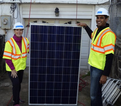 Karen and her WGL colleague pose by a solar panel