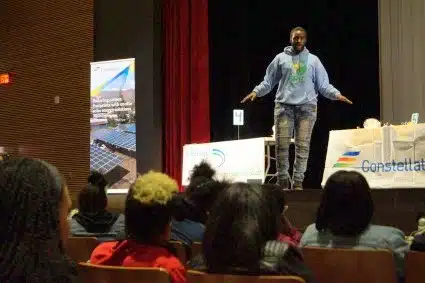 Keon Coutler, SolarCorps Construction Fellow, in front of a group of students, explaining his experience.