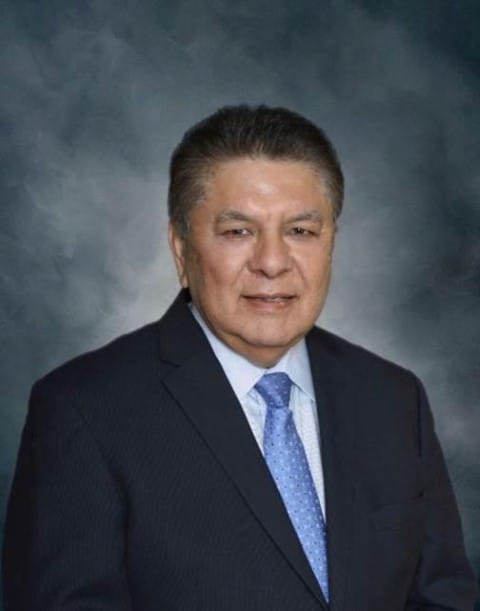 Professional headshot of Luis H. Sanchez wearing a dark suit and blue tie