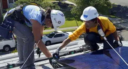 Ayaz and Nadine, a Junior Solar Installation Supervisor, install a solar module