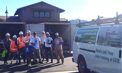 Group of construction workers and trainees standing near a van advertising free job training at GRID