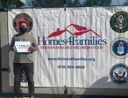 Nick Boateng stands in front of a Homes4Families banner