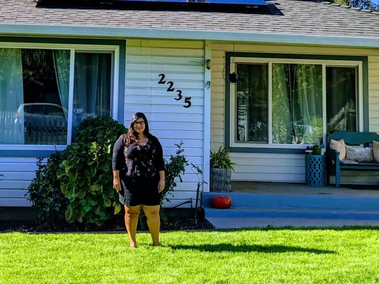 Woman standing on lawn in front of house numbered 2235