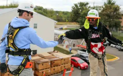Dave, a  GRID SIS hands Reggie a tool
