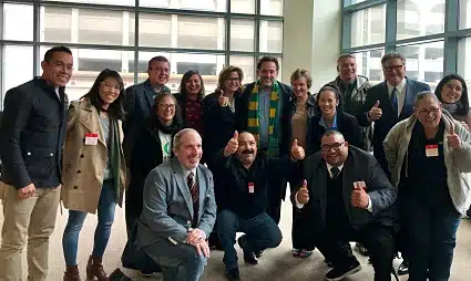 Group of diverse professionals posing together at TCC Coalition event in modern office space
