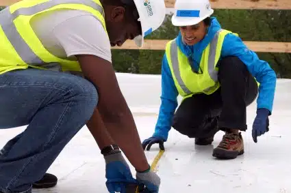 Two HAND volunteers lay out the foundation for solar panels