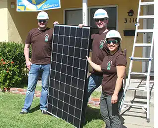People hold solar panel in hardhats