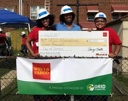 Wells Fargo volunteers stand with a large check, their donation to GRID!