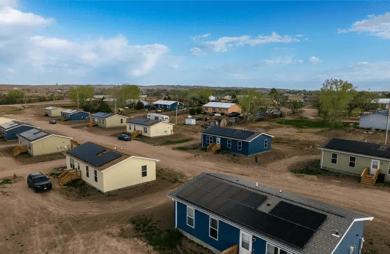 An aerial view of a neighbourhood of single-storey homes with solar arrays on their roofs.
