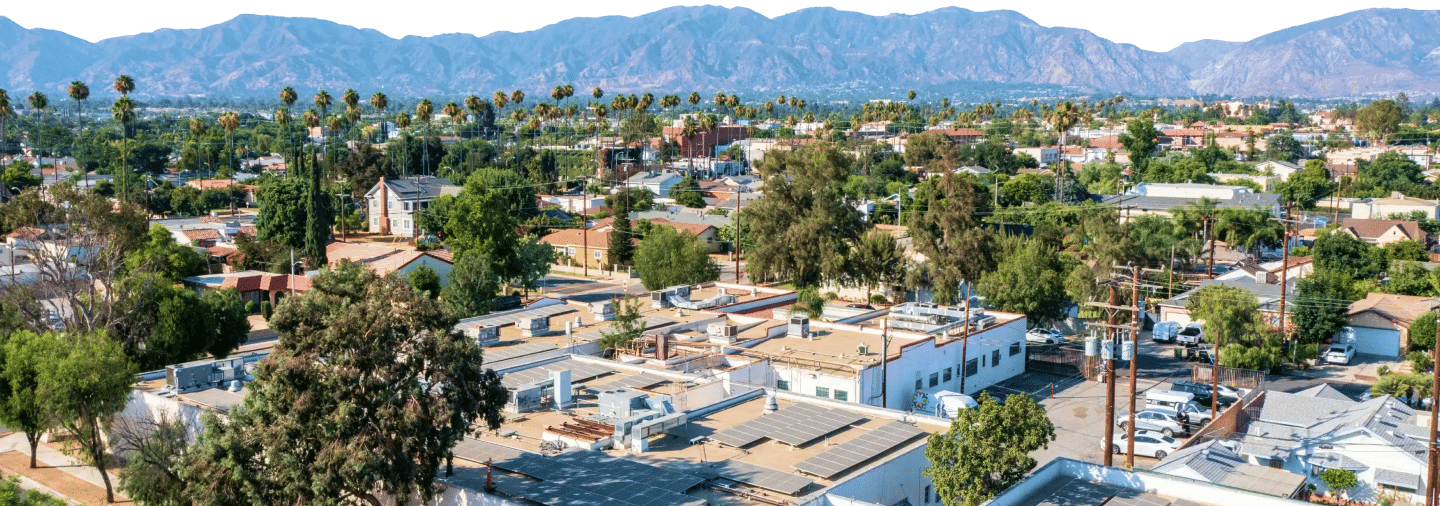 A city skyline cut out against the sky, rooftops carrying solar arrays.