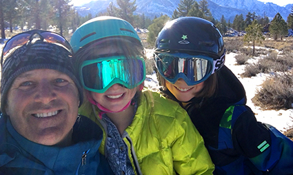 Scott Smith smiles on the ski mountain with his two young children.